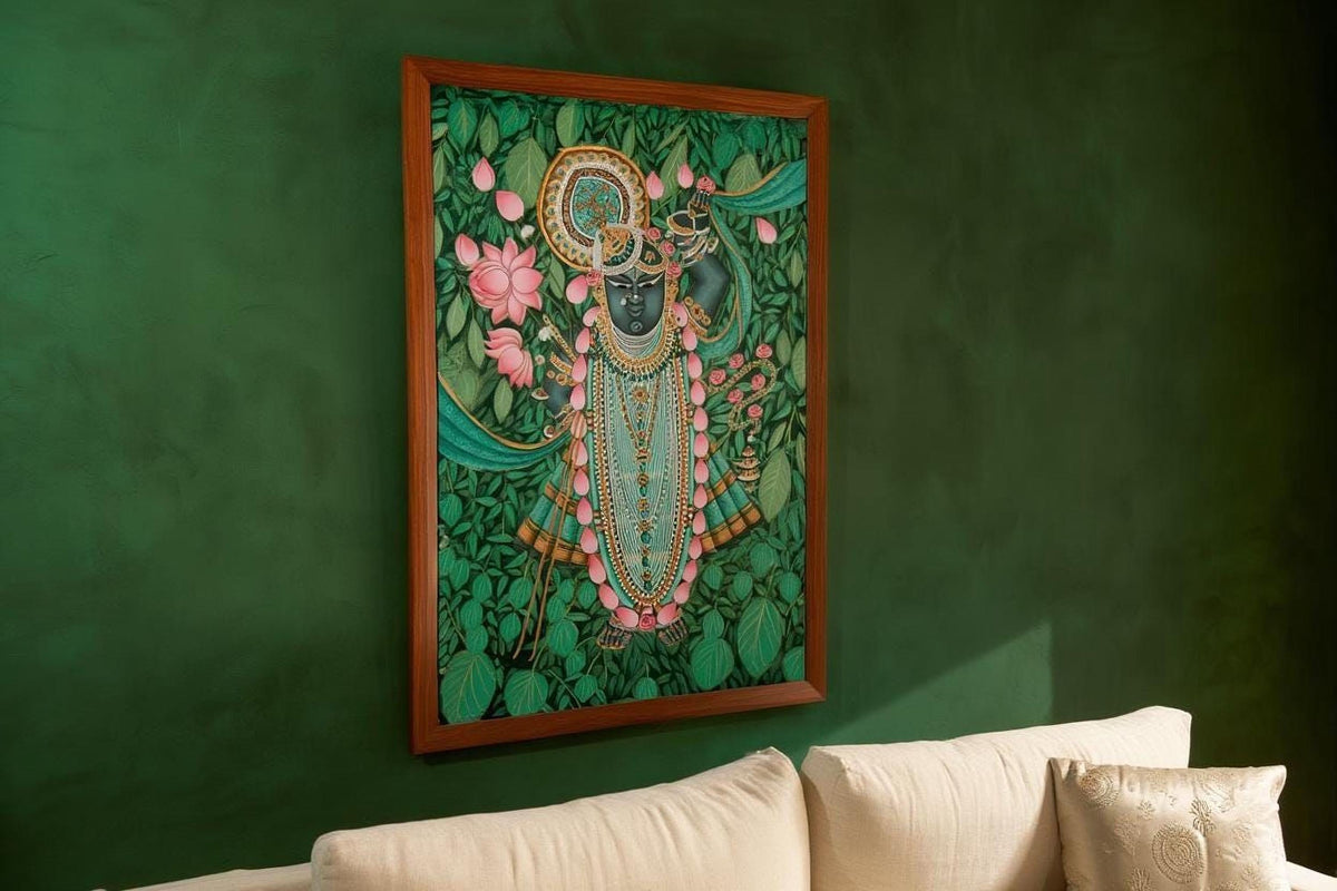 a framed painting of a Hindu deity, likely a representation of the Hindu deity Krishna, displayed on a green wall above a white couch.