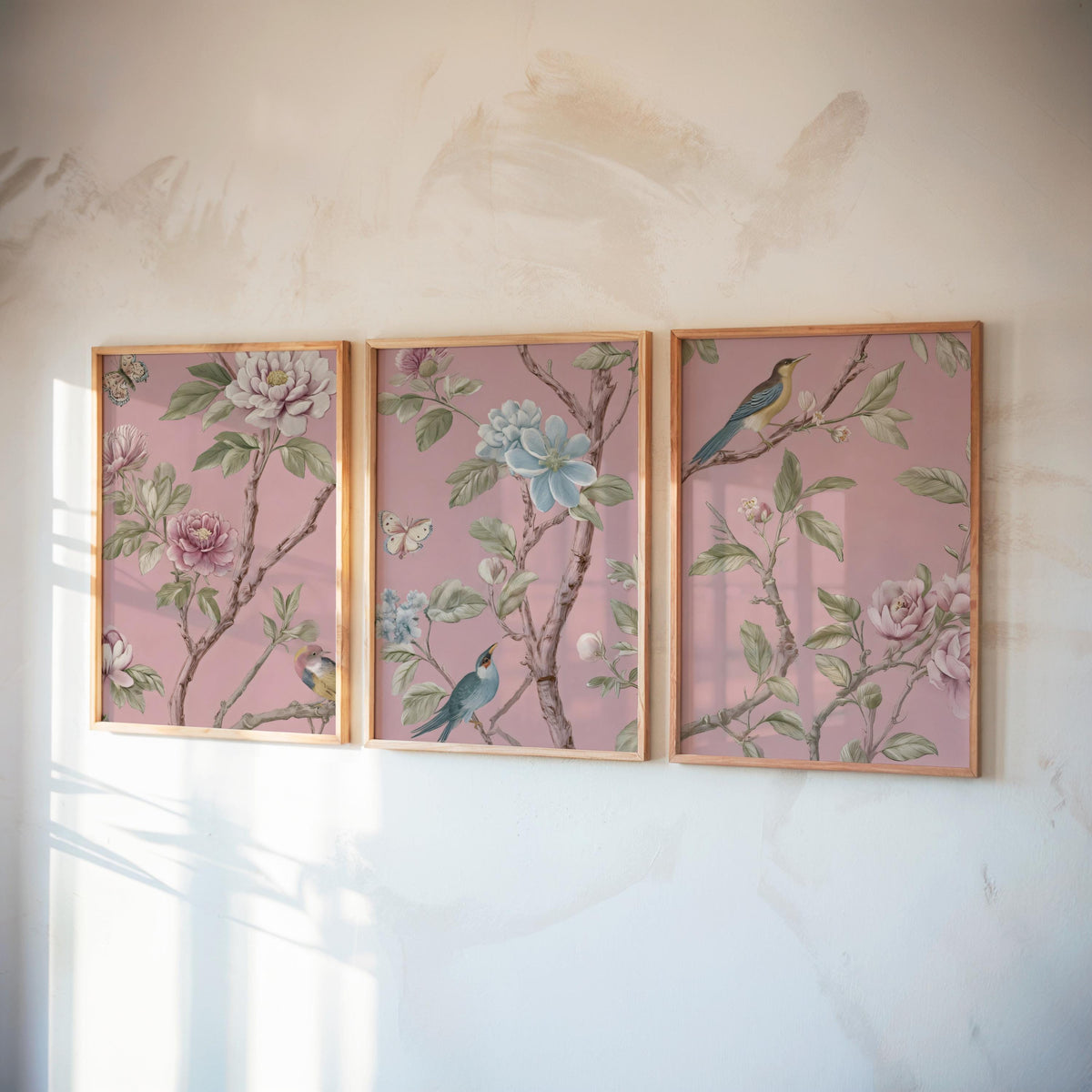 three framed pictures of birds perched on branches, each with a different color scheme and floral design.
