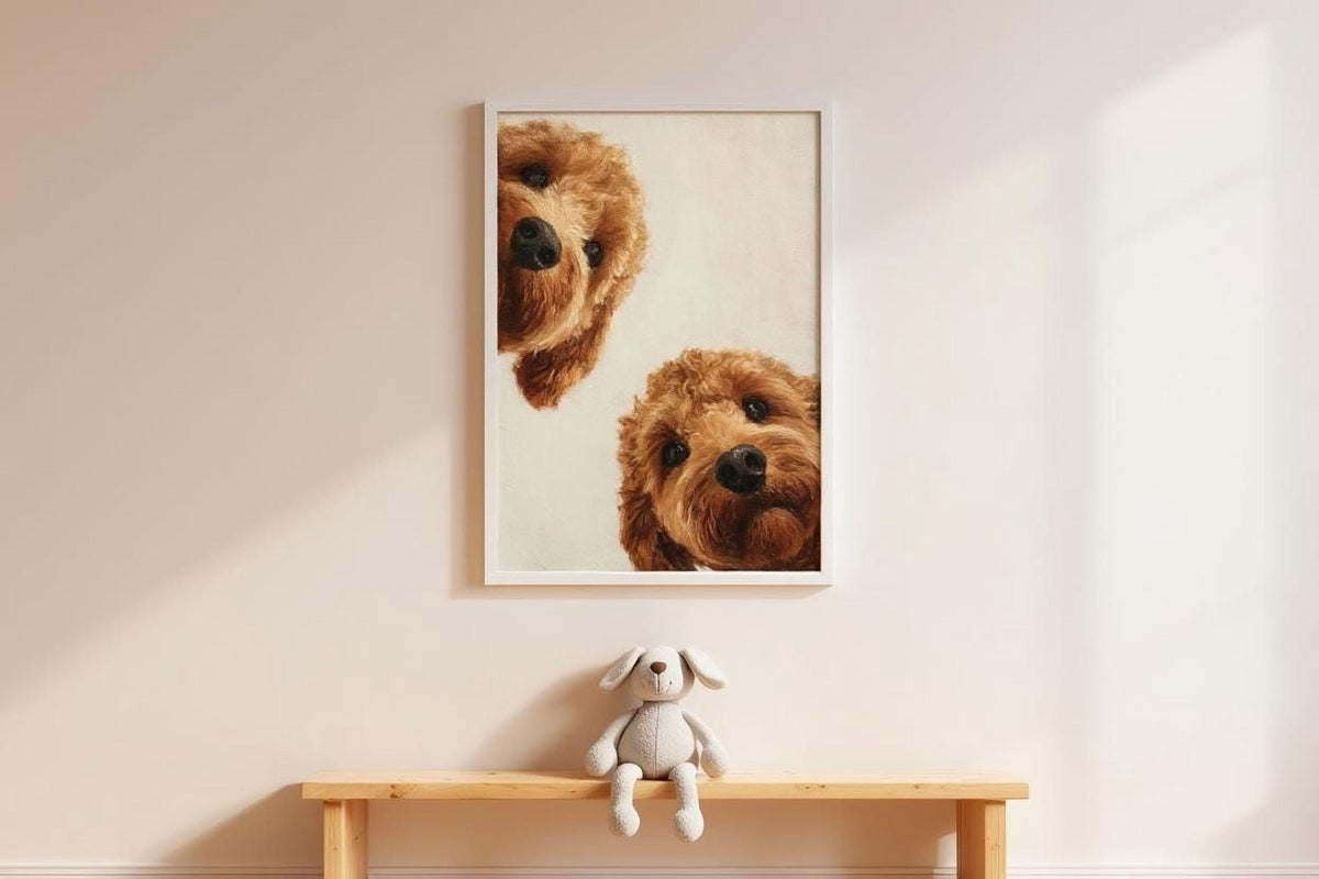 A framed picture of two brown dogs peeking out from behind a wooden bench, with a stuffed animal dog sitting on the bench below.