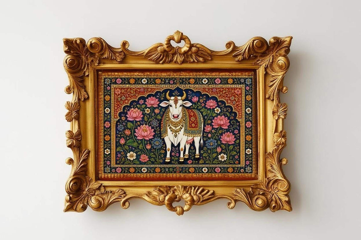 a decorative gold frame with an ornate border, containing a painting of a cow surrounded by a floral and ornamental design.