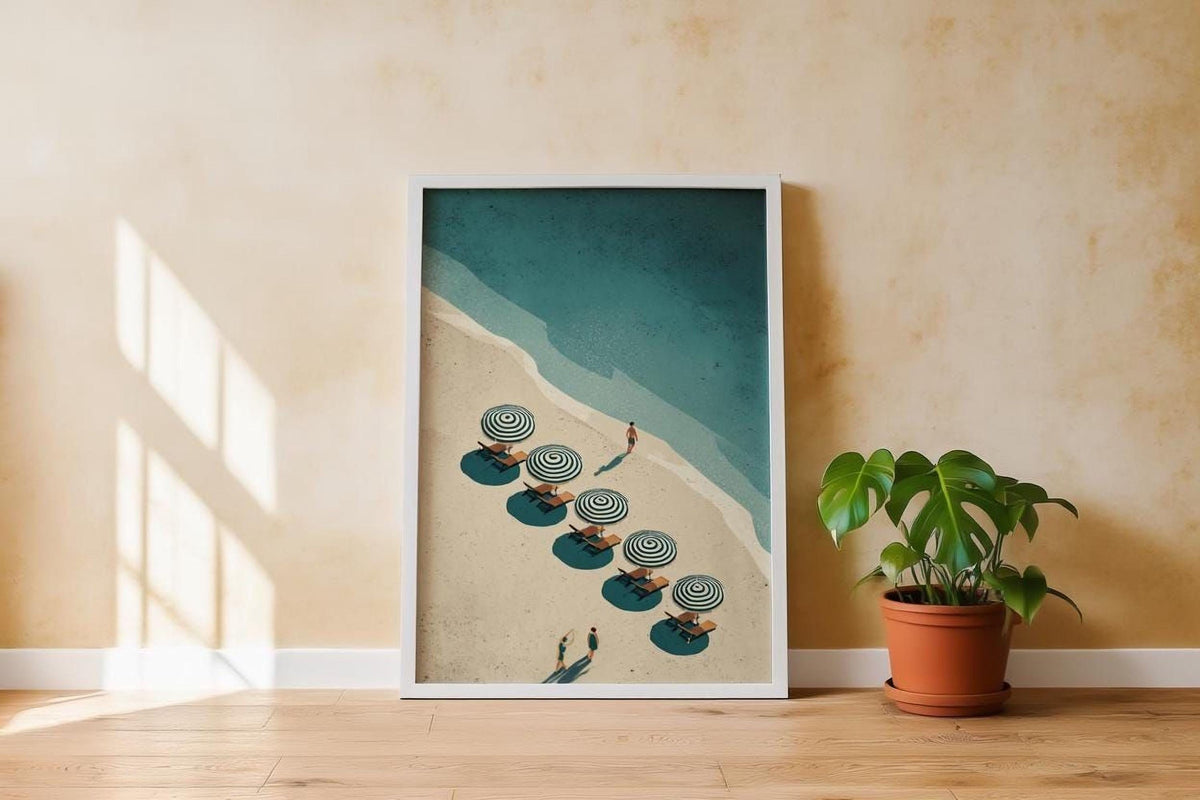 a framed poster of a beach scene with people relaxing under umbrellas on a sandy beach.