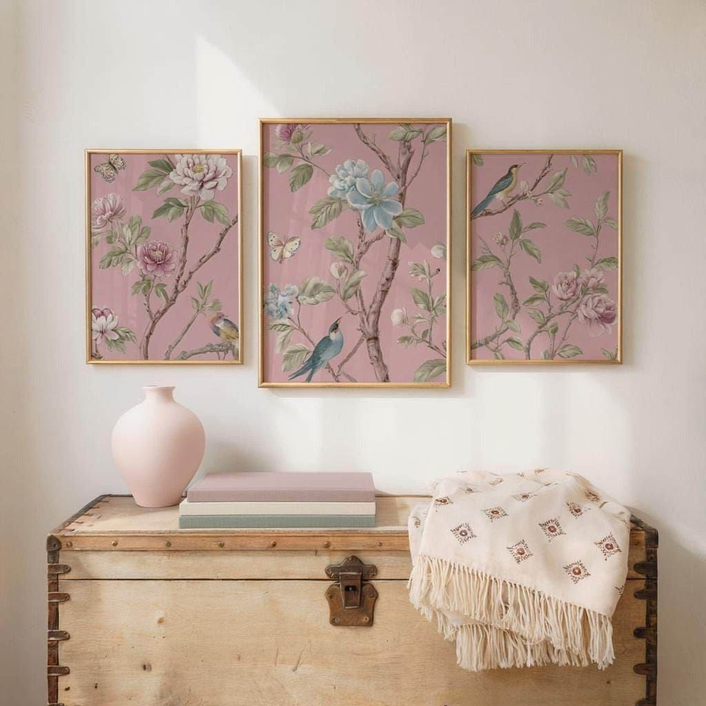 a wooden trunk with three framed floral paintings hanging above it, creating a decorative and harmonious display.