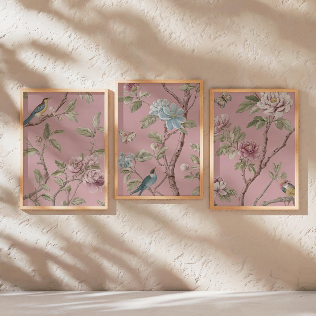 three framed pictures of birds perched on branches with flowers, displayed on a wall.