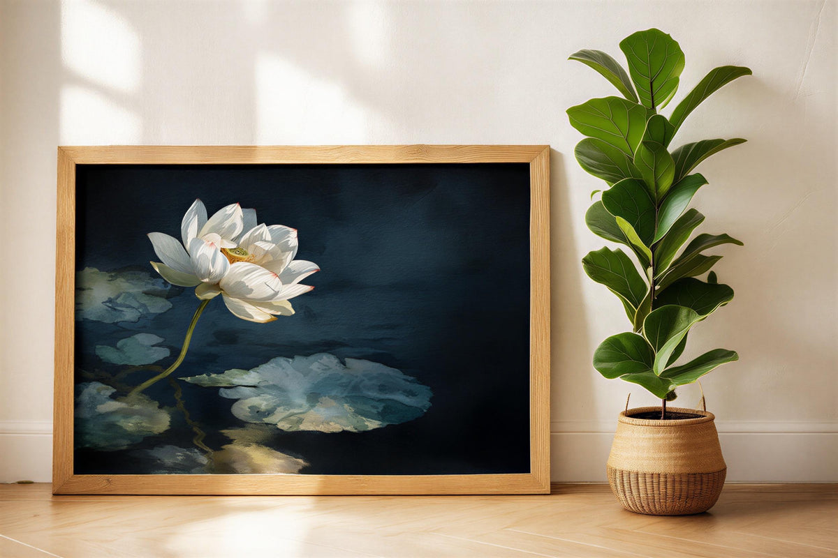 White lotus wall art in a warm wood frame beside a potted plant, lotus pond painting look, moody floral art print for entryway