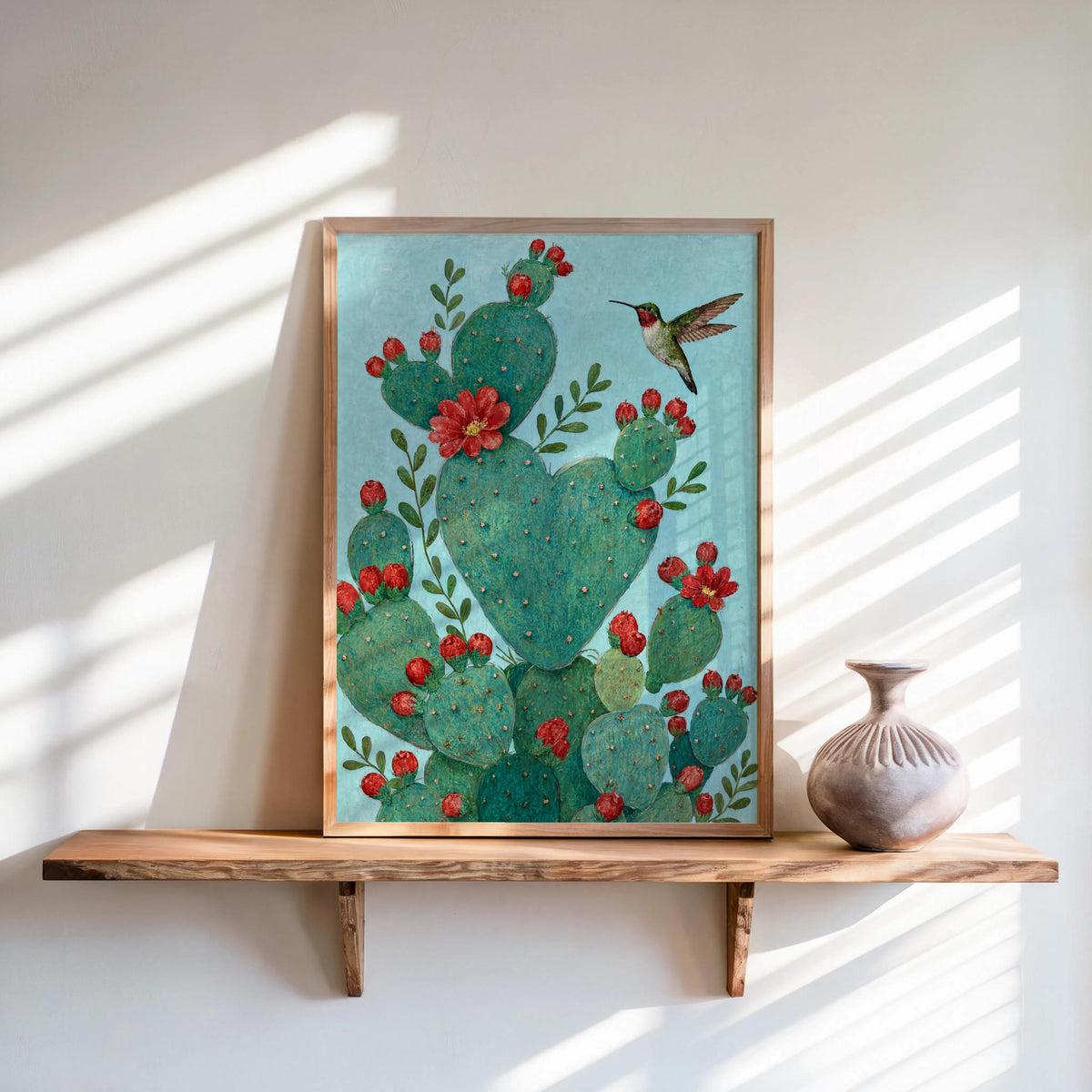 Cropped shelf view of heart shaped cactus print, vibrant red flowers, desert botanical wall art styling