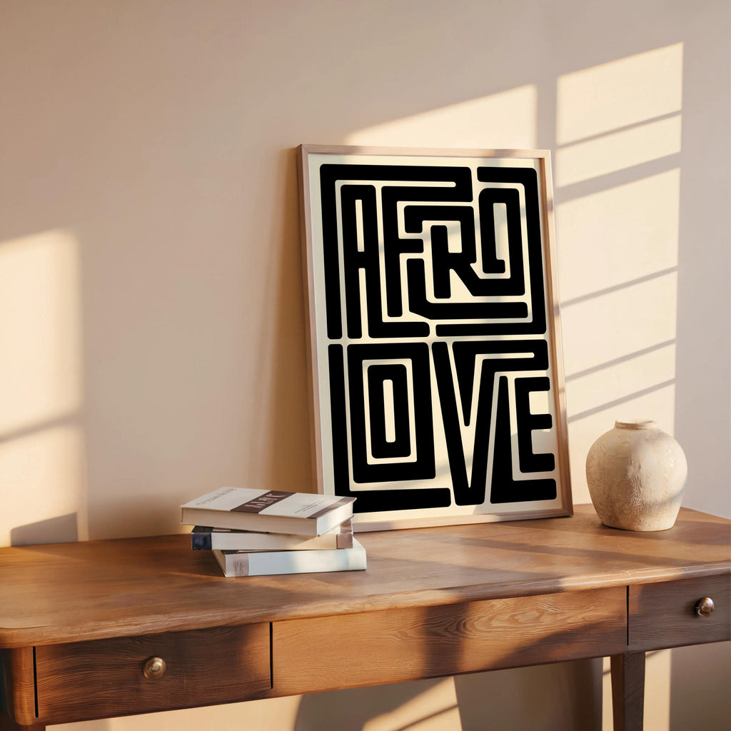Afro Love wall art leaning on rustic desk with books and pottery, warm sunlight, Black joy home decor feel