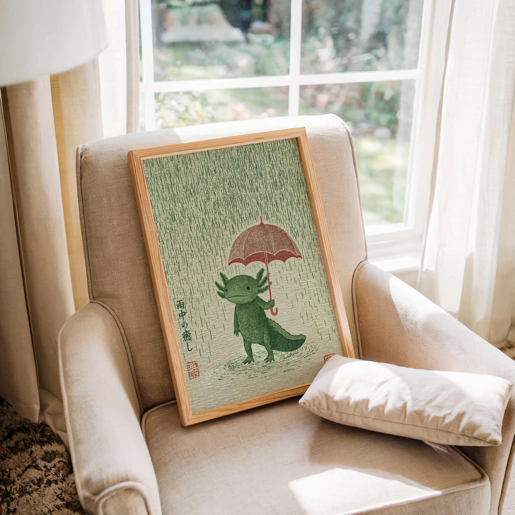 Axolotl Wall Art Print resting on a cozy armchair by a window, green amphibian decor, warm natural light
