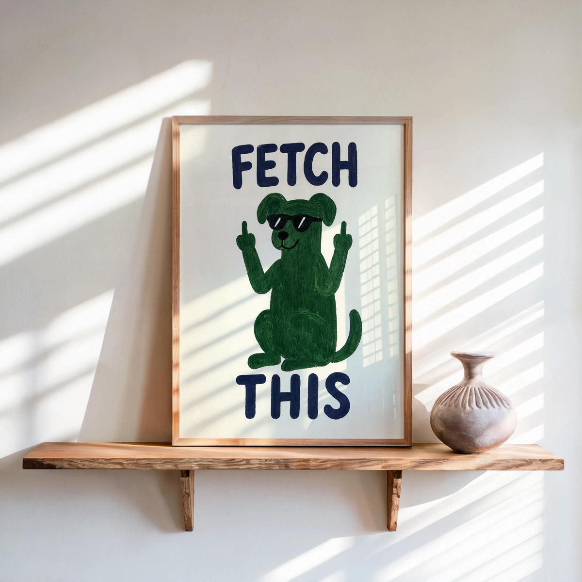 Styled shelf scene, framed green dog FETCH THIS print with small ceramic vase and sunlight, playful fetch this print decor