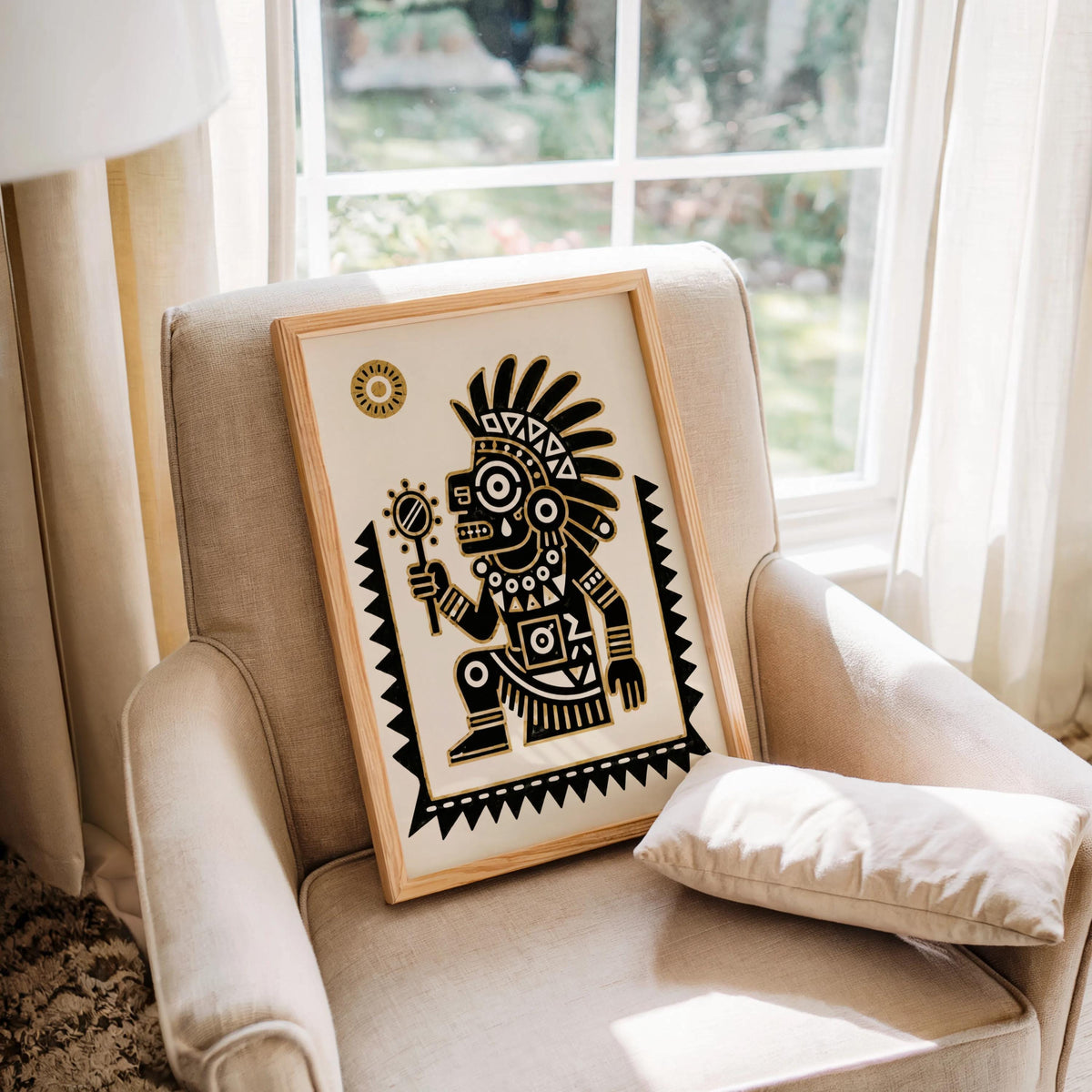 Tezcatlipoca wall art framed on a cozy armchair by window, close crop shows paper texture and bold lines