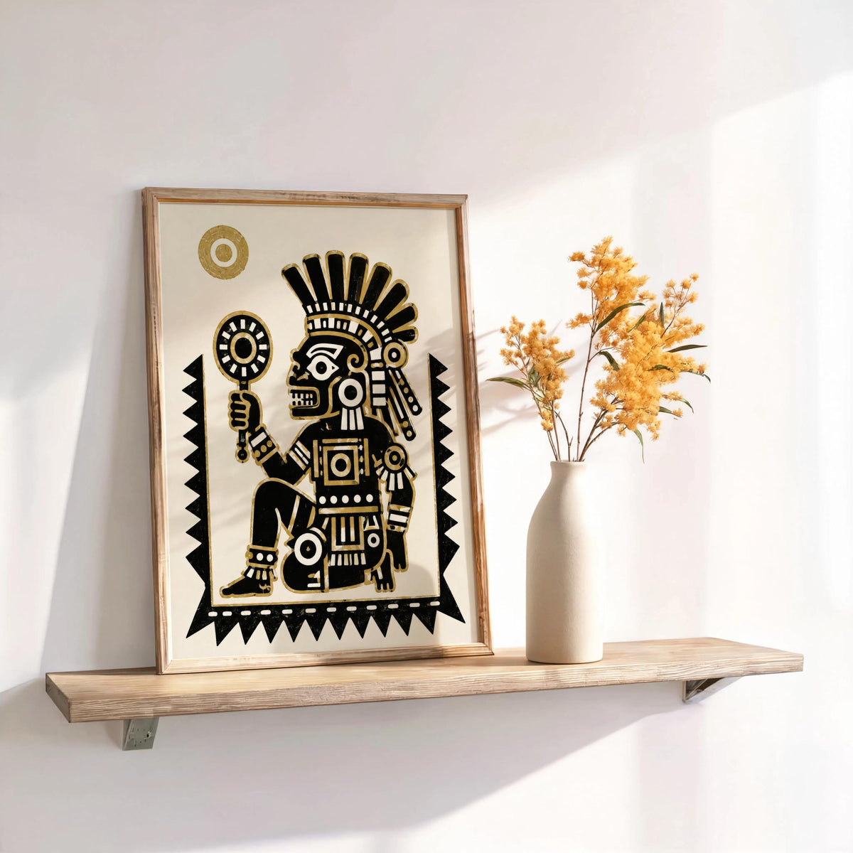 Tezcatlipoca art print propped beside a vase of dried flowers, warm light highlights feathered headdress
