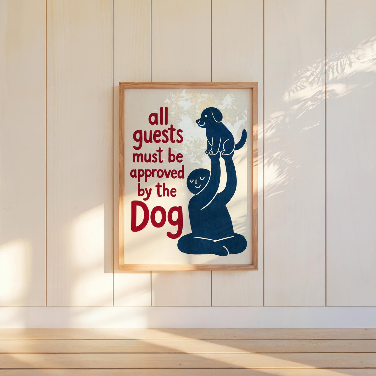 Blue dog print hung in a tall frame on painted shiplap, warm light and floor shadow, dog house rules sign vibe