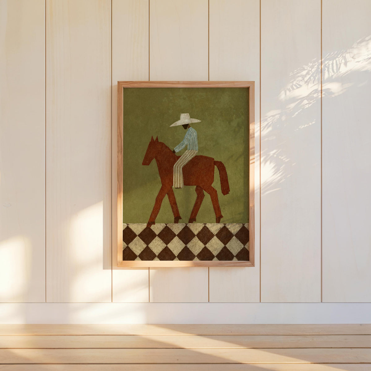 Centered framed cowboy horse print on white paneled wall, cream hat and terracotta tones, mid century western decor feel