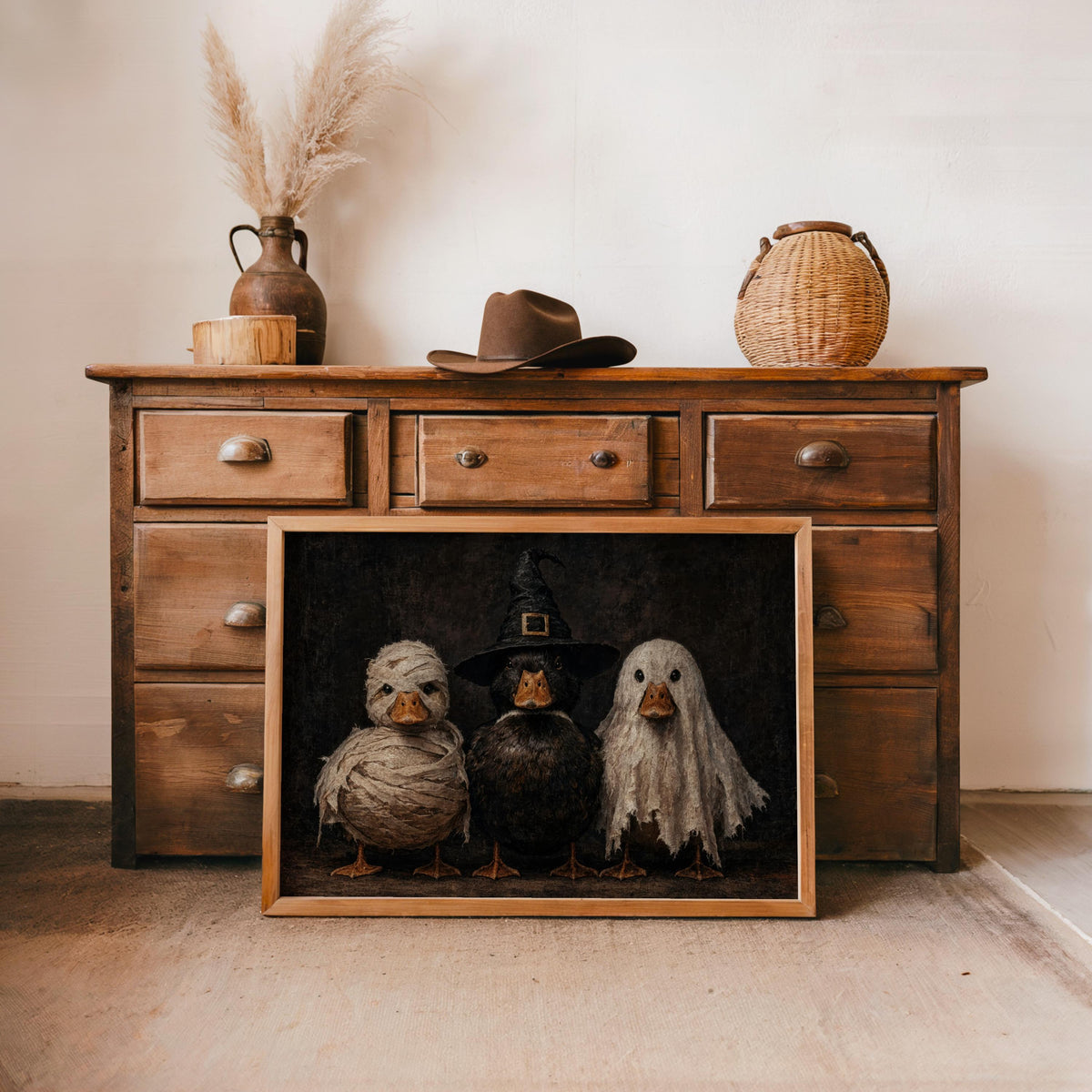 Framed Halloween duck wall art placed against a rustic dresser, warm wood styling, funny duck print with gothic Halloween vibe