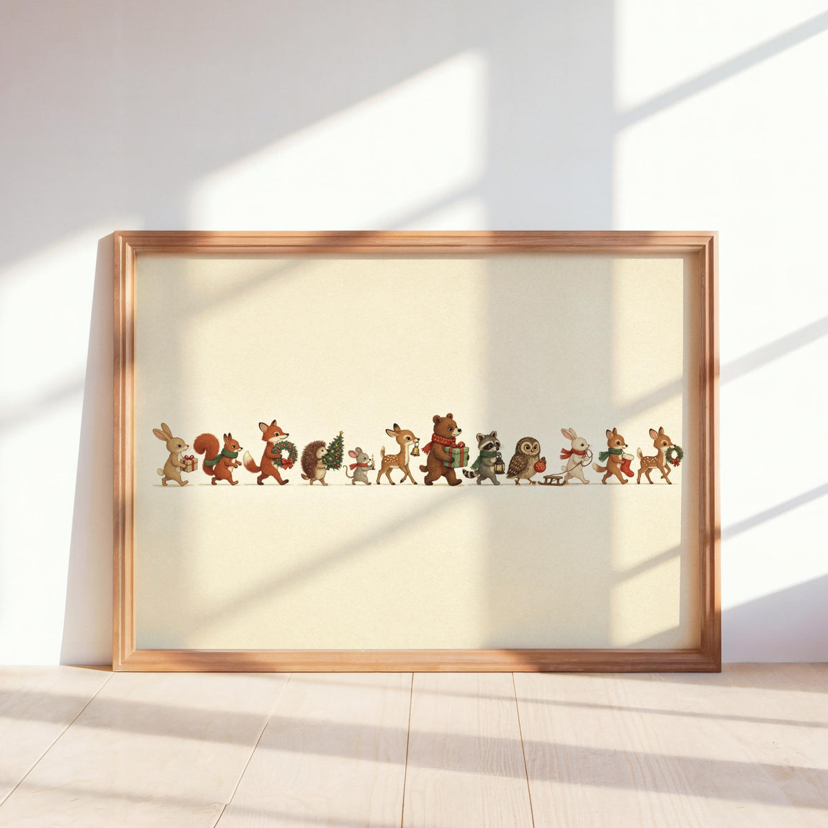 Framed Christmas woodland animals print leaning on a sunlit shelf, warm cream background and wooden frame
