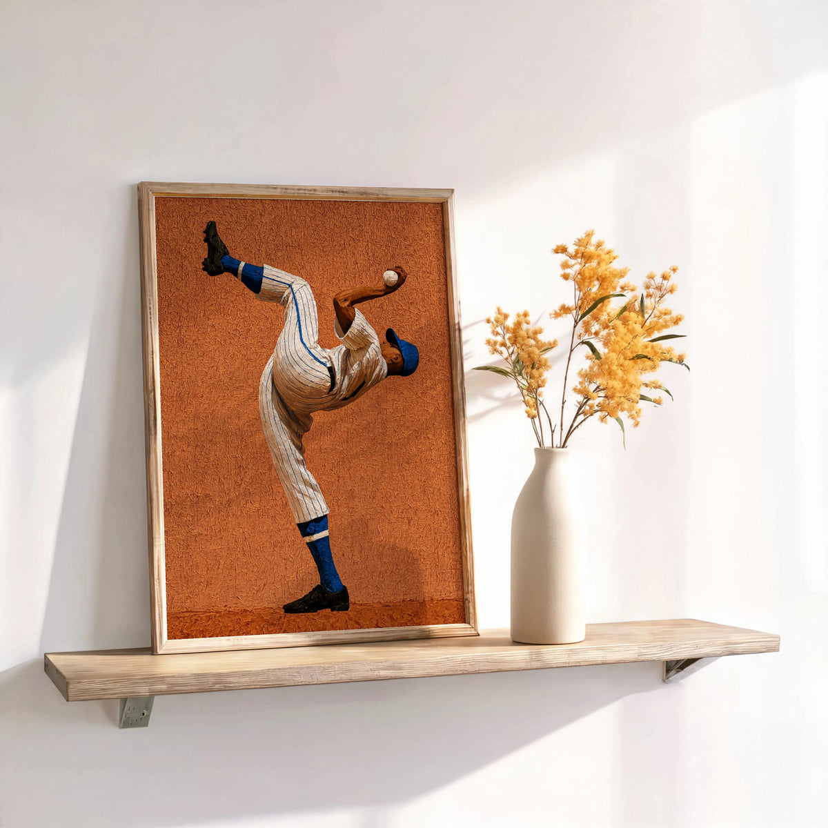 Shelved framed burnt orange pitcher print with dried vase on wood shelf, stylized Afrocentric sports art, baseball pitcher wall art for boys room