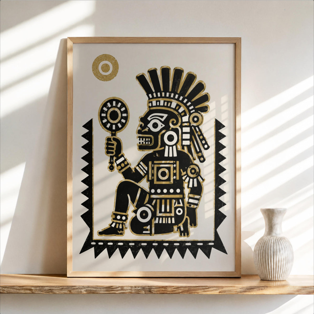 Framed Tezcatlipoca art print leaning on a sunlit shelf, bold black graphic with gold accents