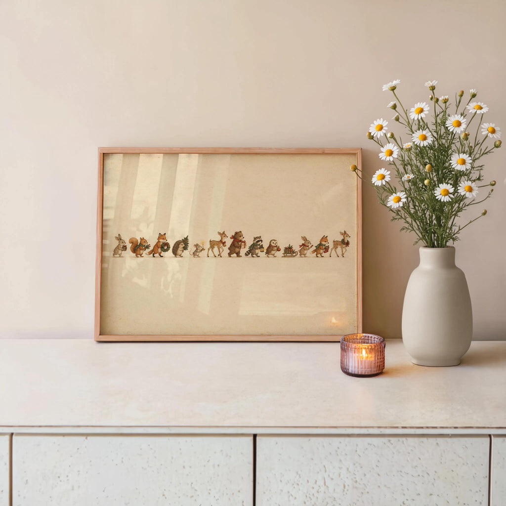 Woodland animal Christmas print resting on a cabinet beside a vase of flowers and a glowing candle