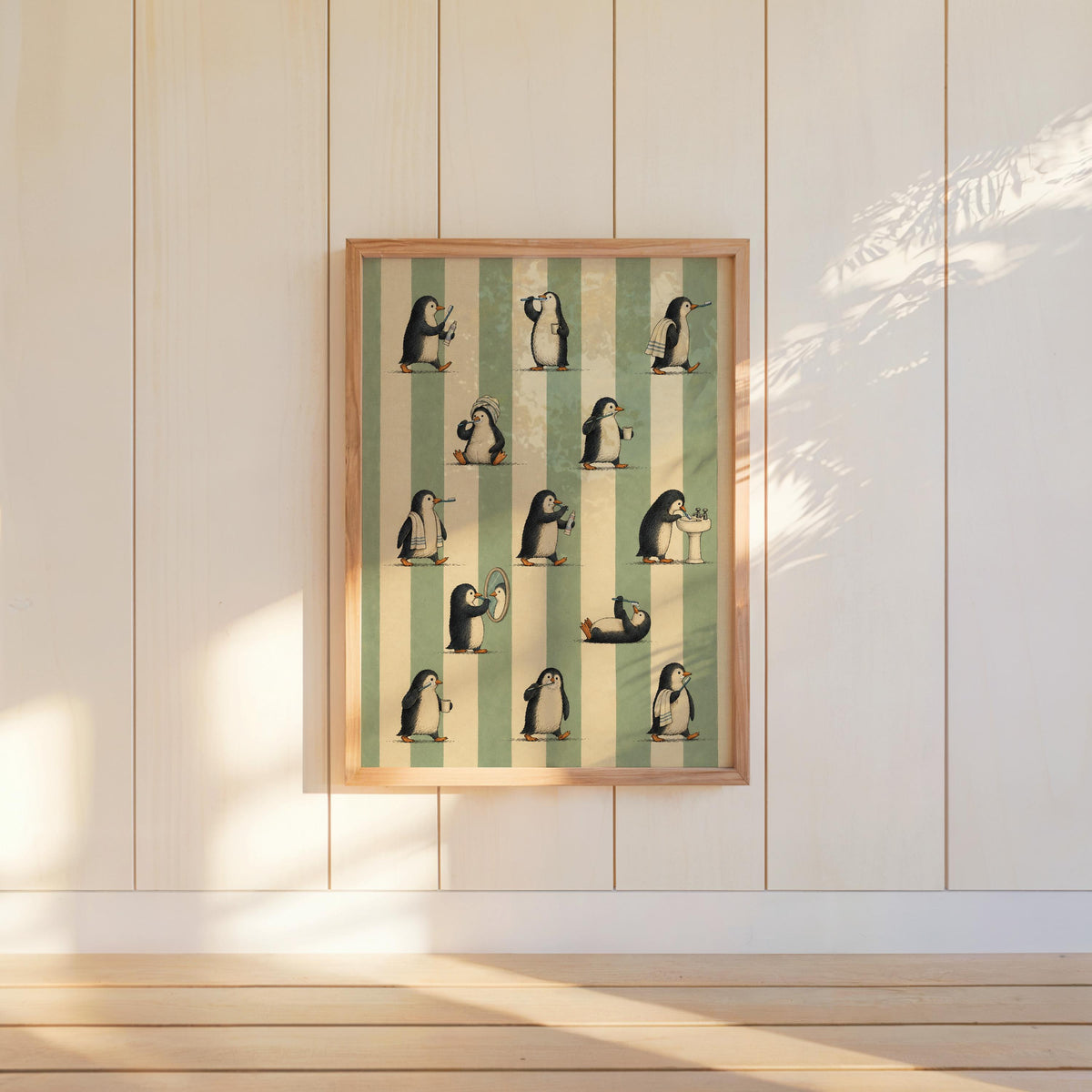 Framed penguin bathroom wall art centered on white paneled wall, sage green stripes catching soft sunlight