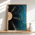 Framed vertical vinyl record wall art resting on rustic wood shelf, turquoise-grooved pool, warm cream label