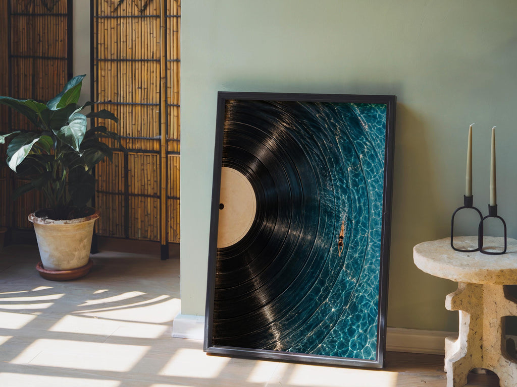 Framed vinyl record wall art leaning against a green wall, potted plant and warm light, vinyl record poster look