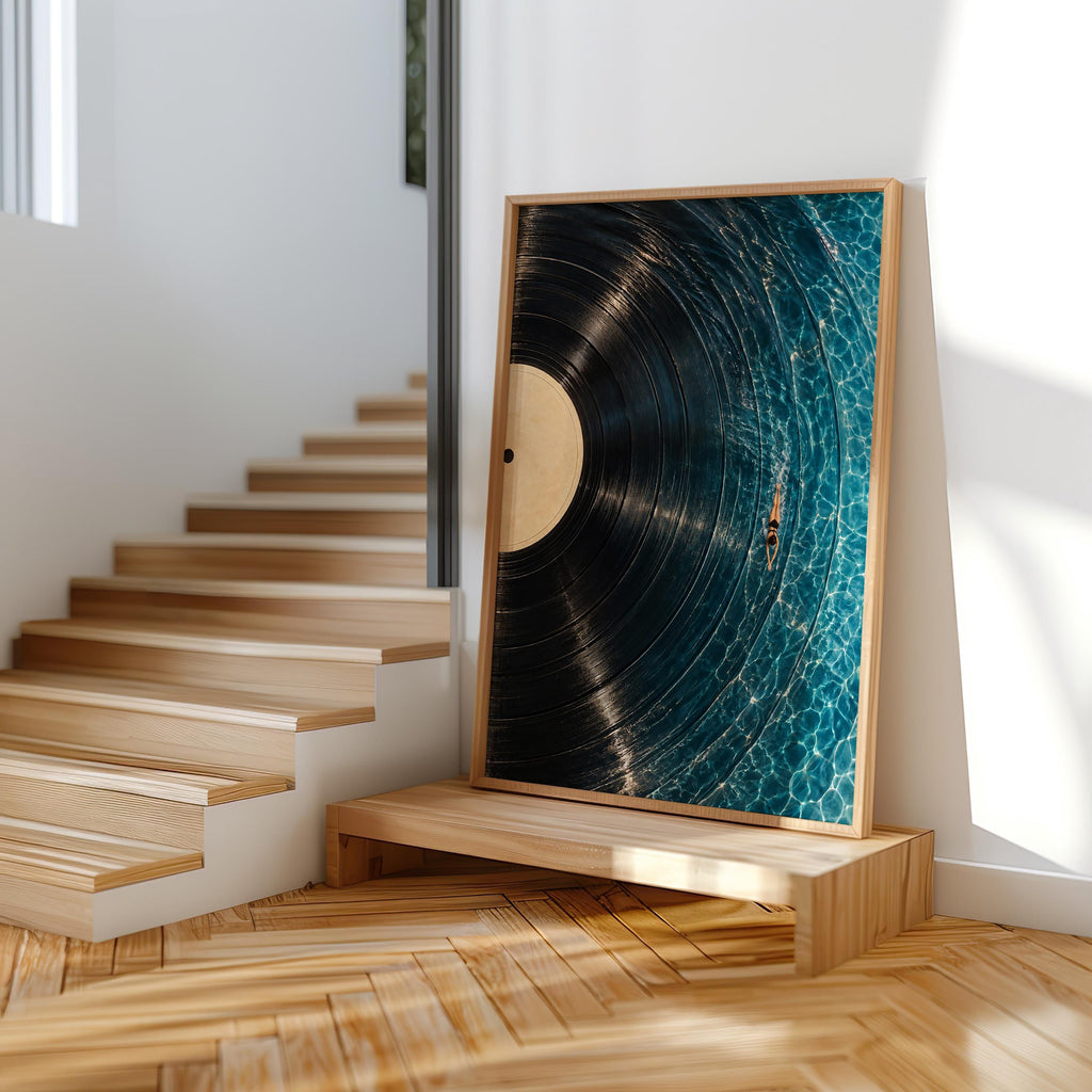 Framed vinyl record wall art by wooden staircase, dramatic side light, modern blue surreal wall art display