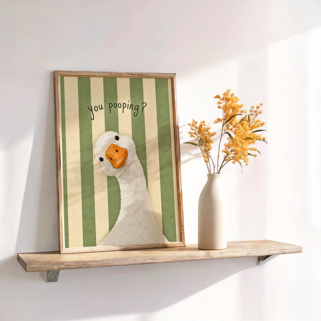 Framed green striped funny goose bathroom print on shelf, bright powder room wall decor with subtle shadows