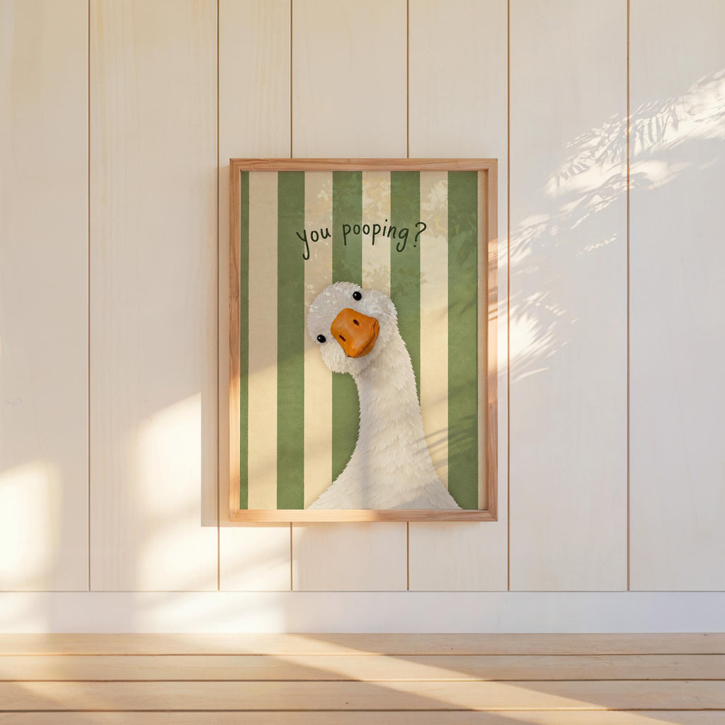 Green striped framed funny goose bathroom print centered on wall, quirky restroom poster vibe with goose peeking