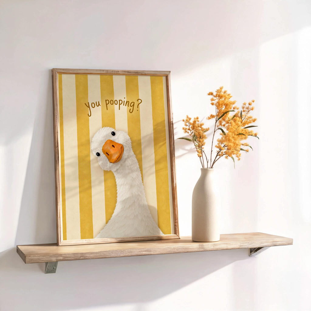 Framed yellow striped funny goose bathroom print on shelf, sunny powder room wall decor with dried stems