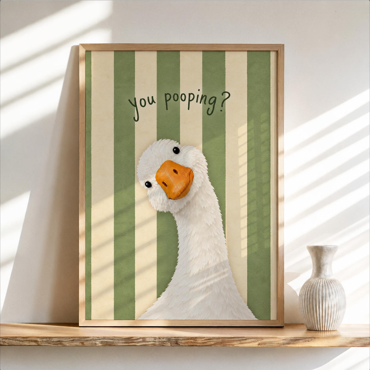 Framed green striped funny goose bathroom print, cheeky white goose peek, playful pooping goose wall art vibe